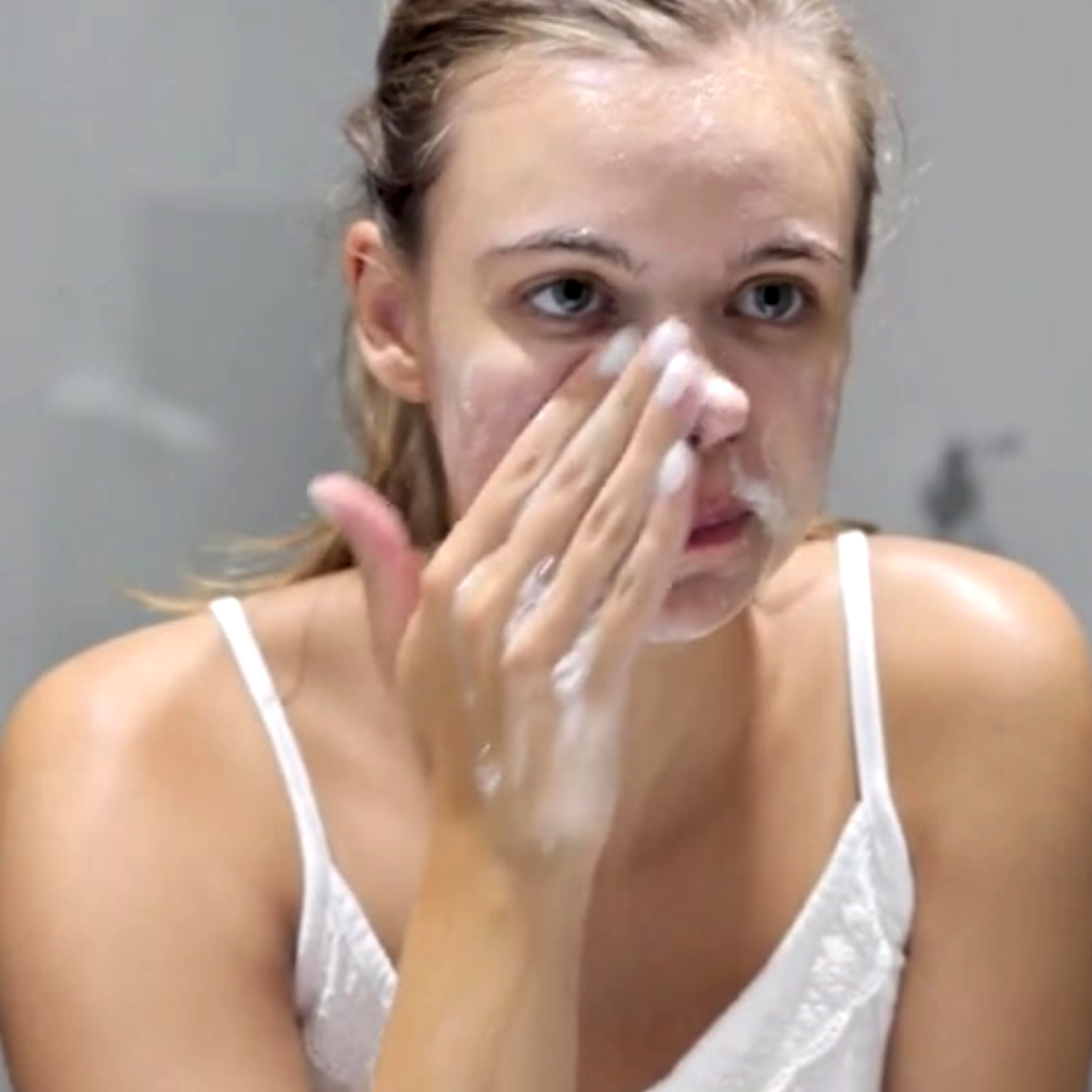 Young women washing face with Lumi Foam Gel cleanser